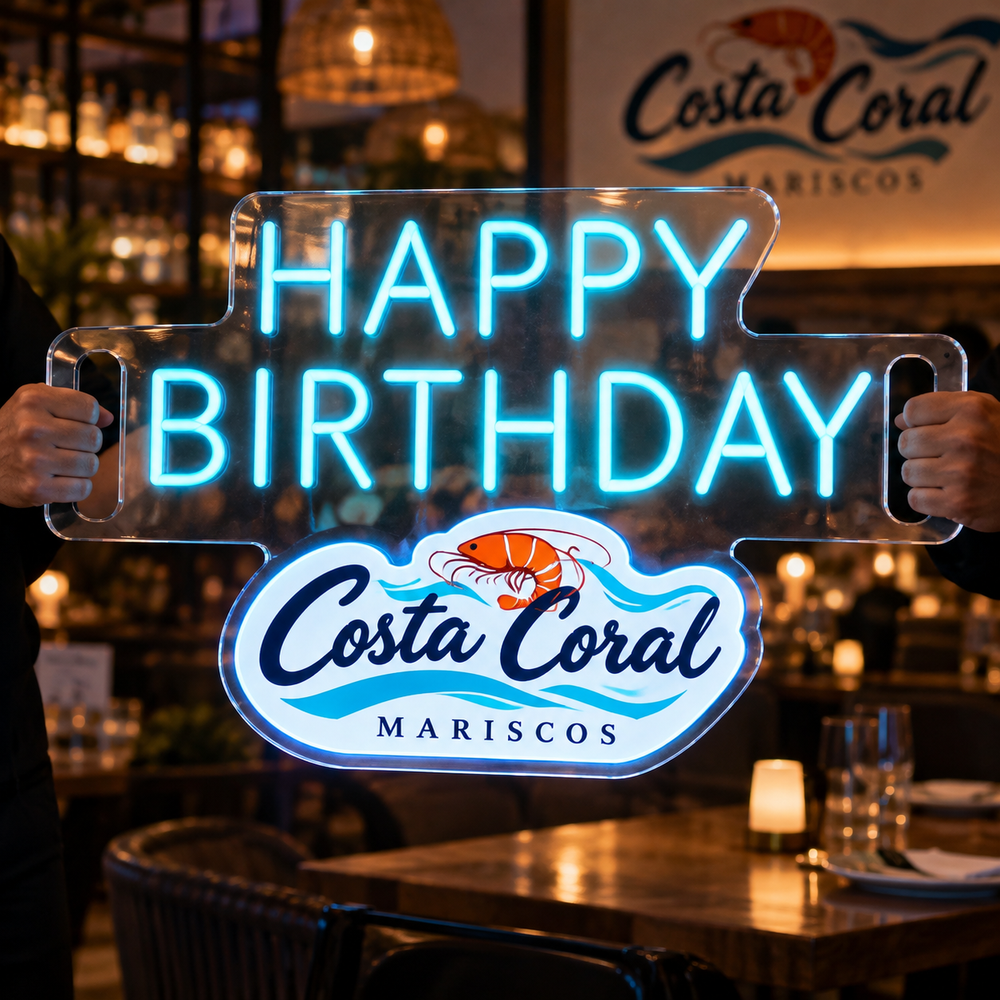 Letrero Happy Birthday azul sostenido con las manos en un restaurante